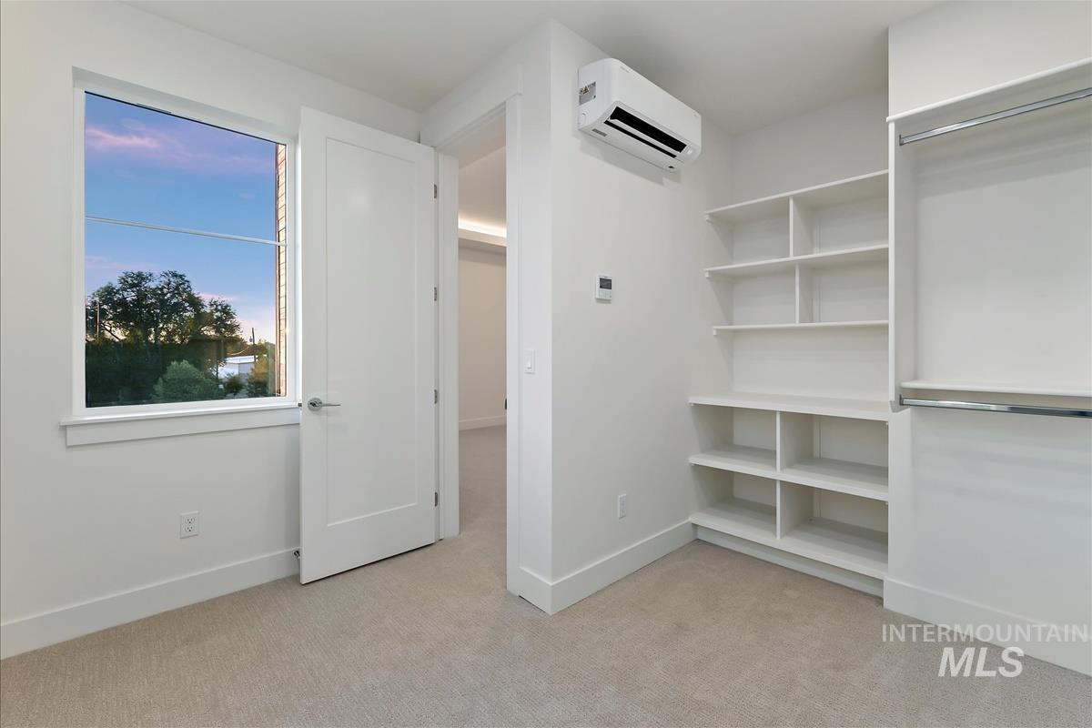 3213 West Moore Street Boise, ID 83702 - Photo 22 of 32 Built-in shelving and hanging rods complement the neutral carpet flooring