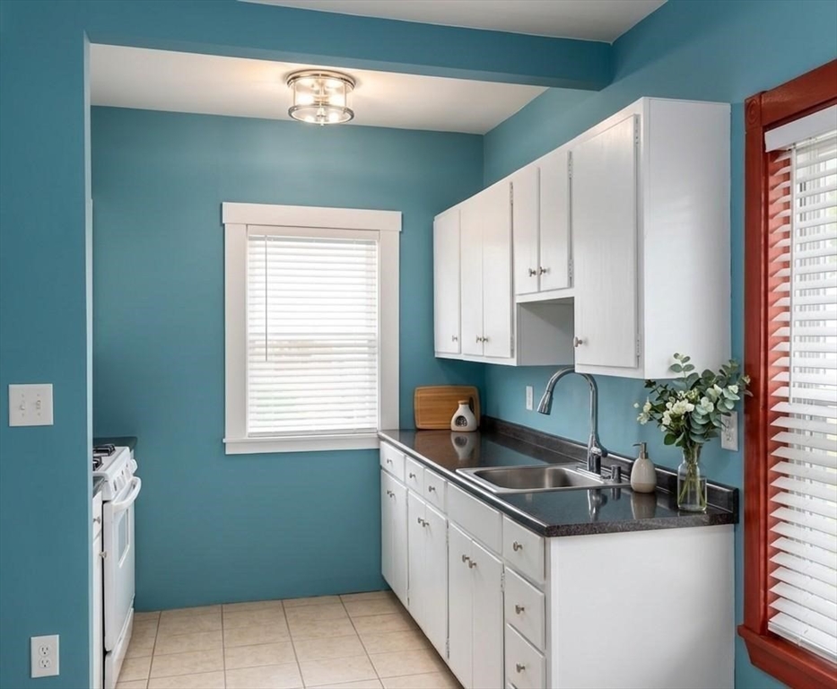 15 Acorn Street, Unit 1 Malden, MA 02148 - Photo 3 of 9 a kitchen with granite countertop a sink a window and stainless steel appliances