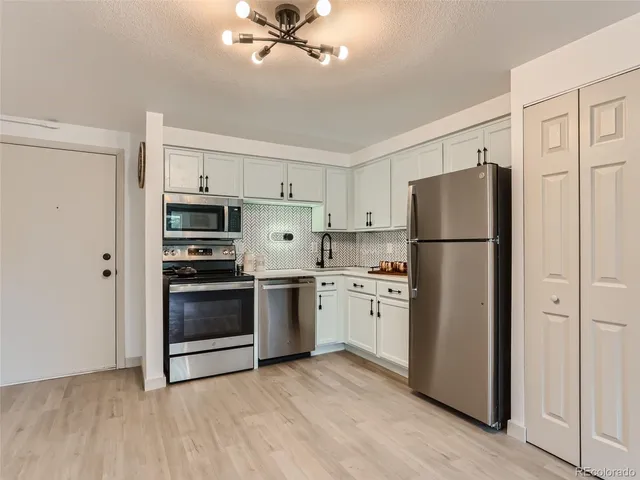 a kitchen with stainless steel appliances a refrigerator and a stove top oven