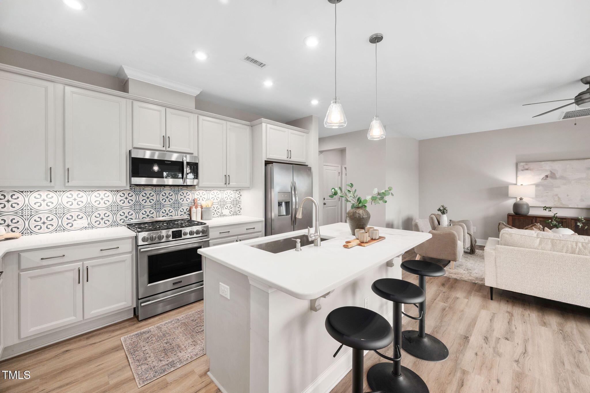 1821 Cypress Cove Drive Wendell, NC 27591 - Photo 6 of 31 a kitchen with kitchen island granite countertop a sink a stove a refrigerator and white cabinets with wooden floor