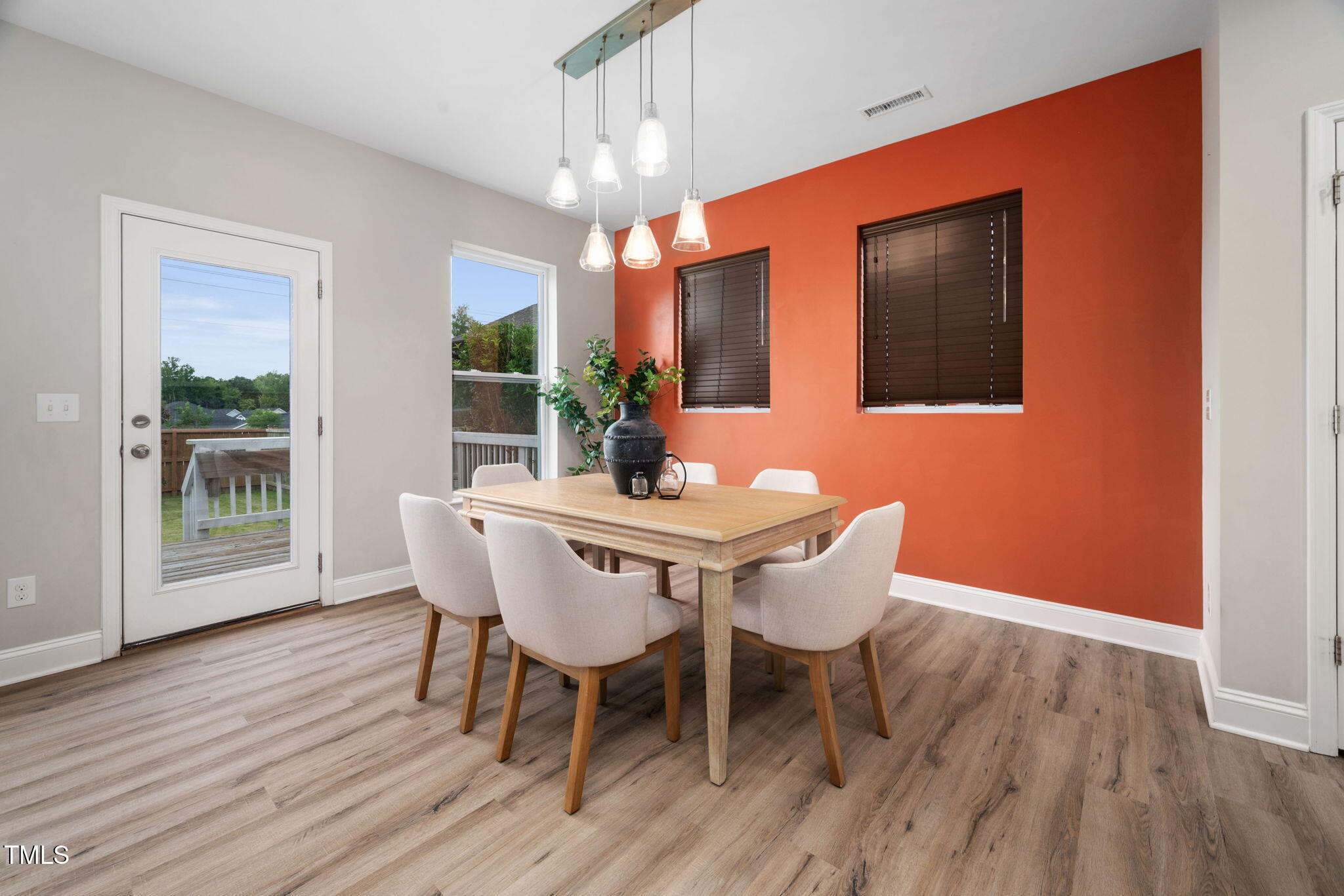 1821 Cypress Cove Drive Wendell, NC 27591 - Photo 9 of 31 a dining room with furniture wooden floor a rug a potted plant and a chandelier