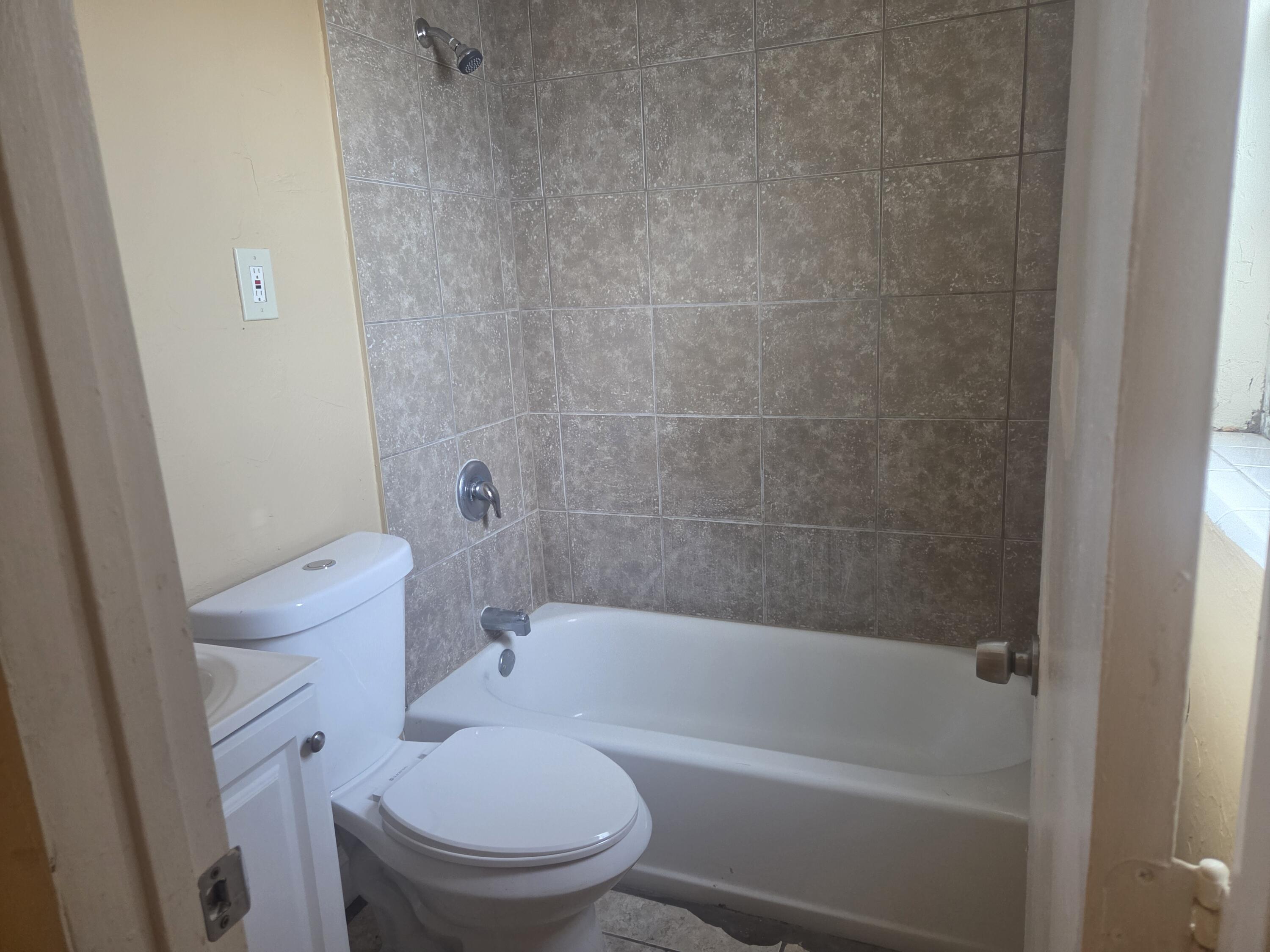 1509 Pine Tree Court Riviera Beach, FL 33404 - Photo 12 of 17 a white bath tub sitting next to a white toilet