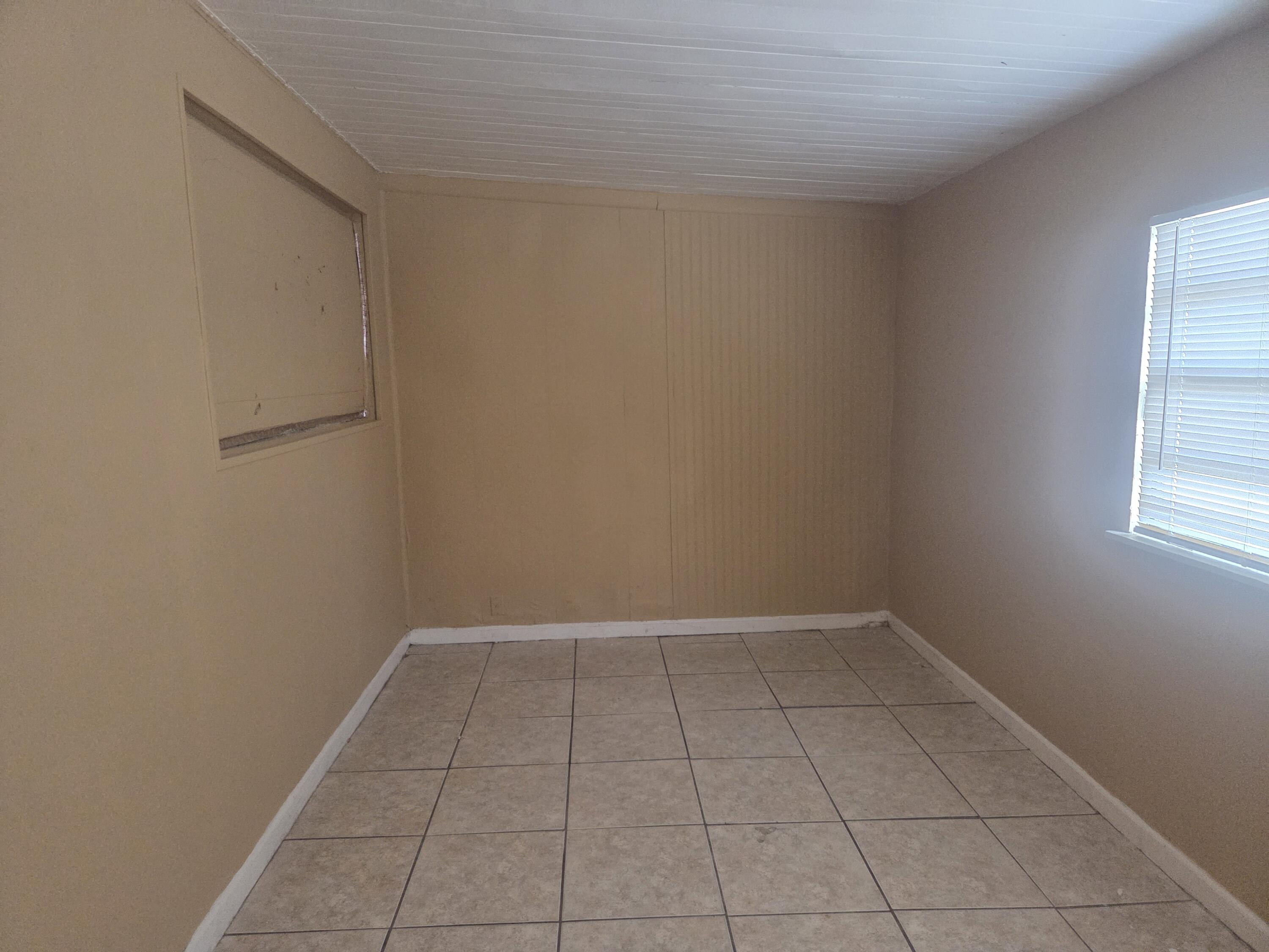 1509 Pine Tree Court Riviera Beach, FL 33404 - Photo 13 of 17 wooden floor in an empty room with a window