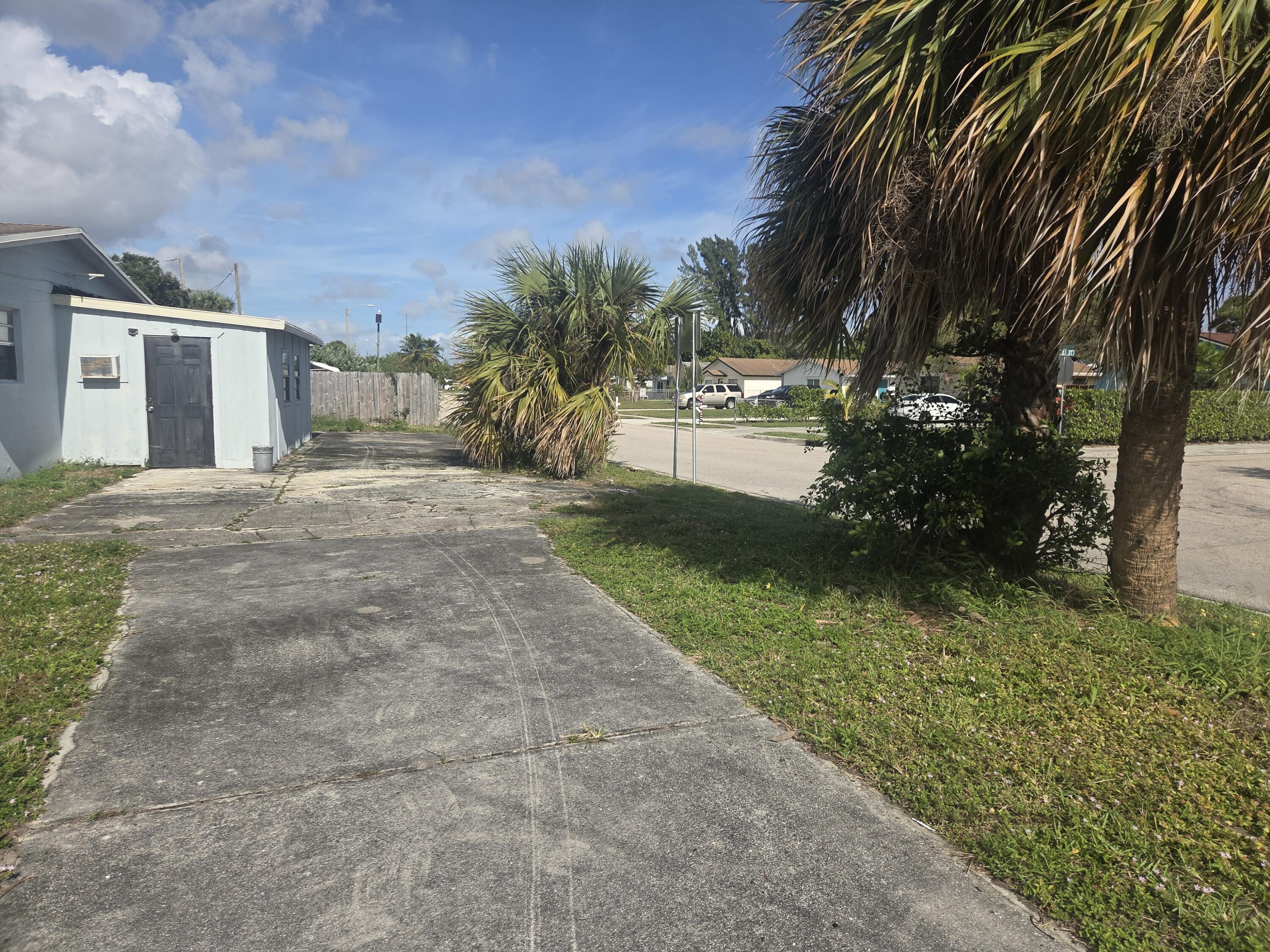 1509 Pine Tree Court Riviera Beach, FL 33404 - Photo 17 of 17 a front view of a house with a yard and a garage