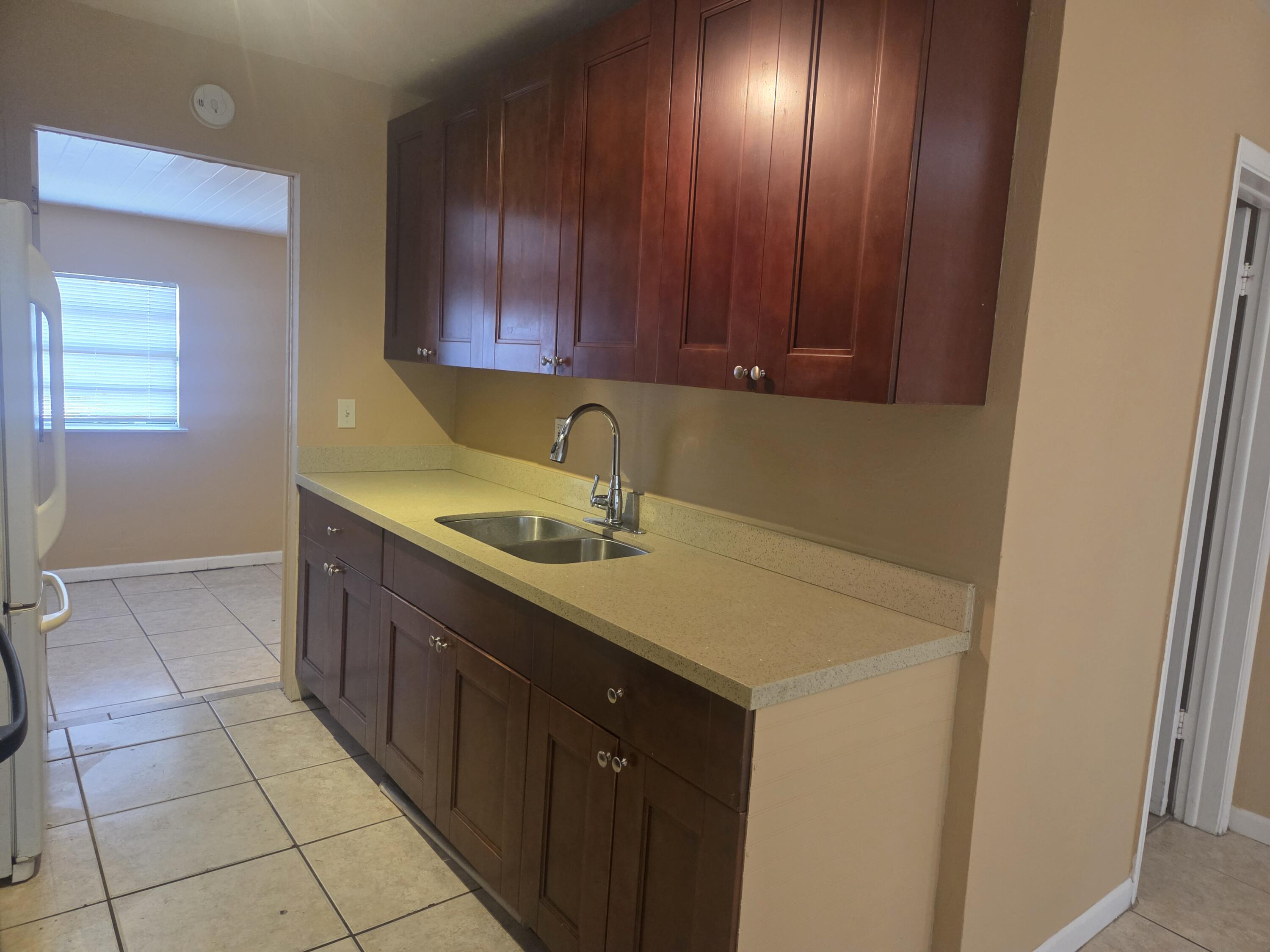 1509 Pine Tree Court Riviera Beach, FL 33404 - Photo 7 of 17 a kitchen with a sink cabinets and utility