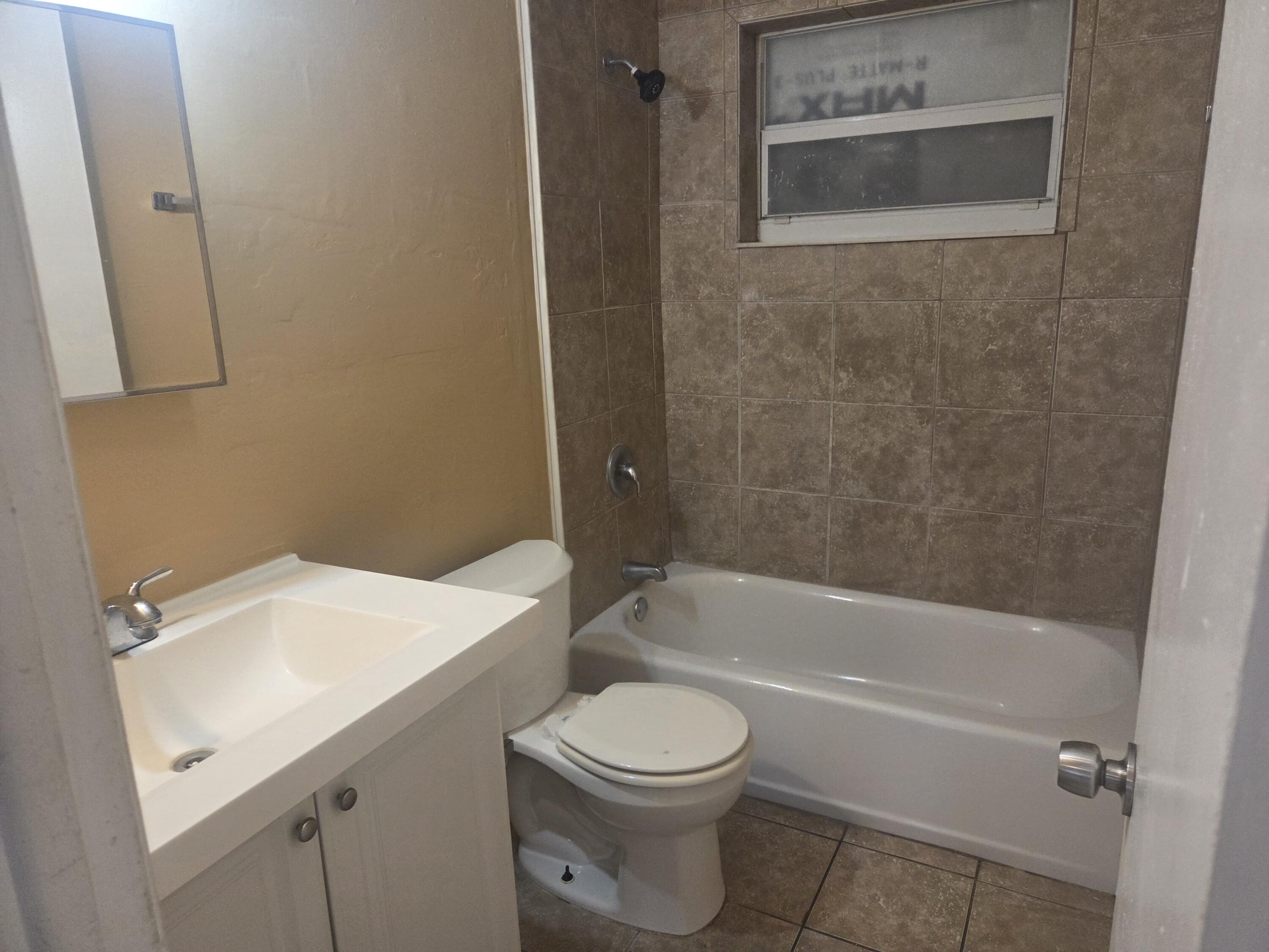 1509 Pine Tree Court Riviera Beach, FL 33404 - Photo 8 of 17 a bathroom with a sink a toilet and a bathtub