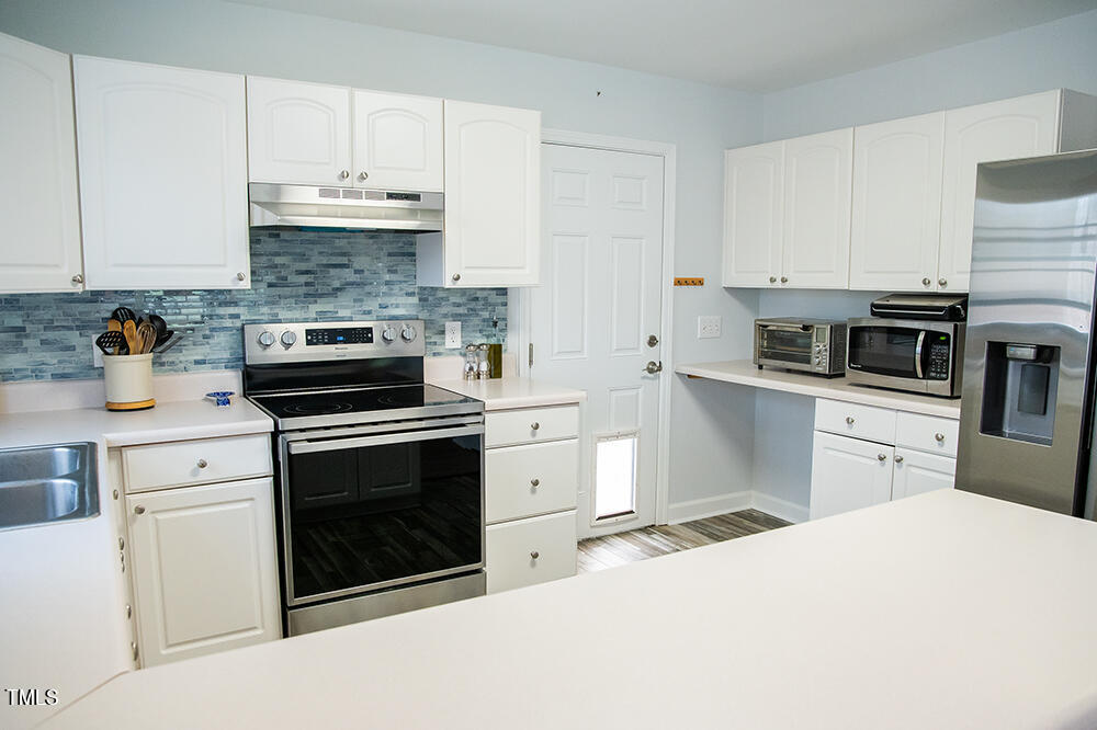 46 Beaver Crossing Road Roxboro, NC 27574 - Photo 14 of 50 a kitchen with cabinets stainless steel appliances and wooden floor