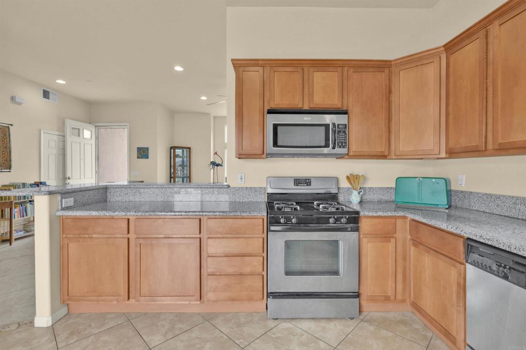 3431 Santa Saba Road Borrego Springs, CA 92004 - Photo 9 of 23 a kitchen with granite countertop a stove top oven microwave and cabinets