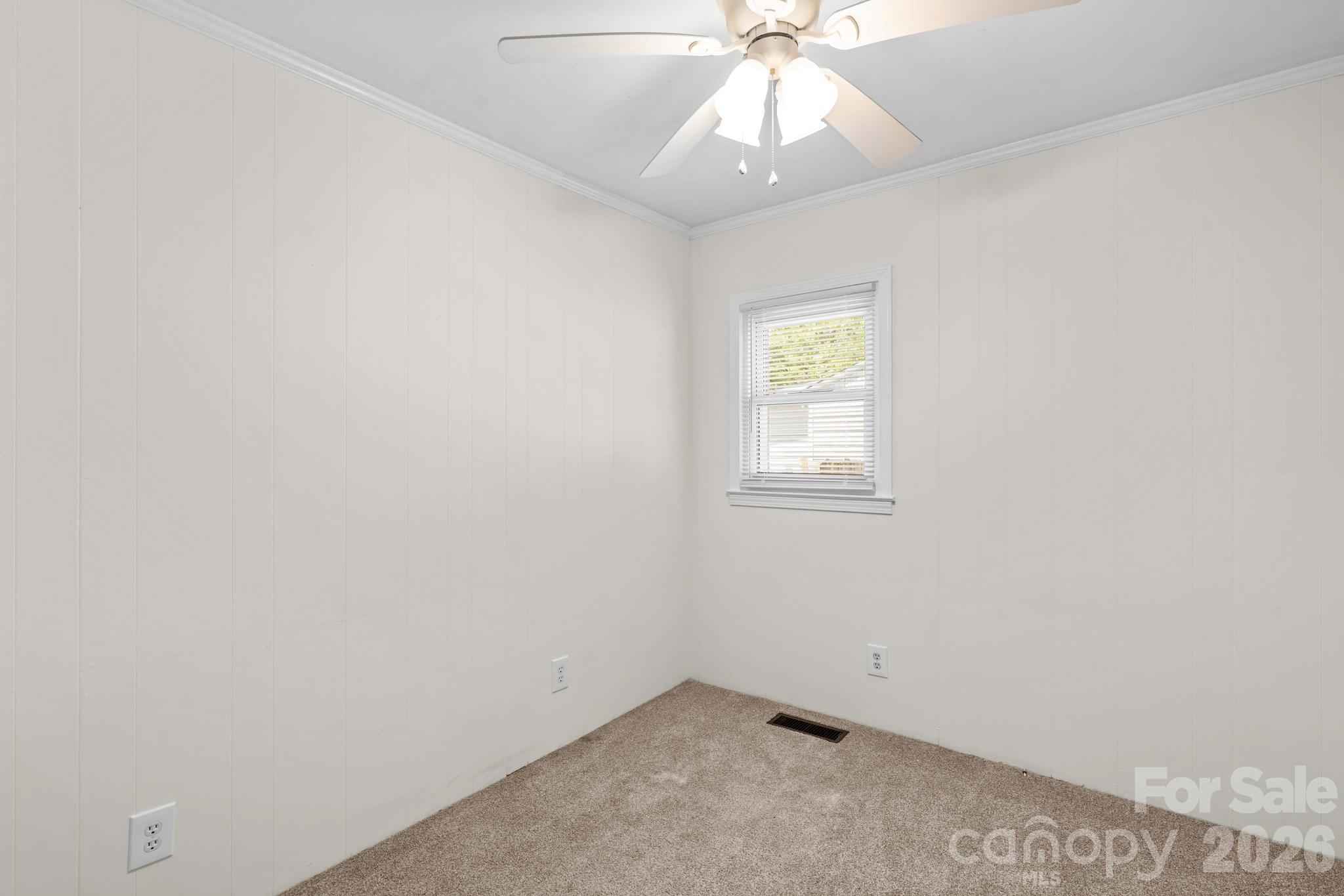 835 Maple Avenue Salisbury, NC 28144 - Photo 26 of 48 an empty room with a window and a chandelier fan