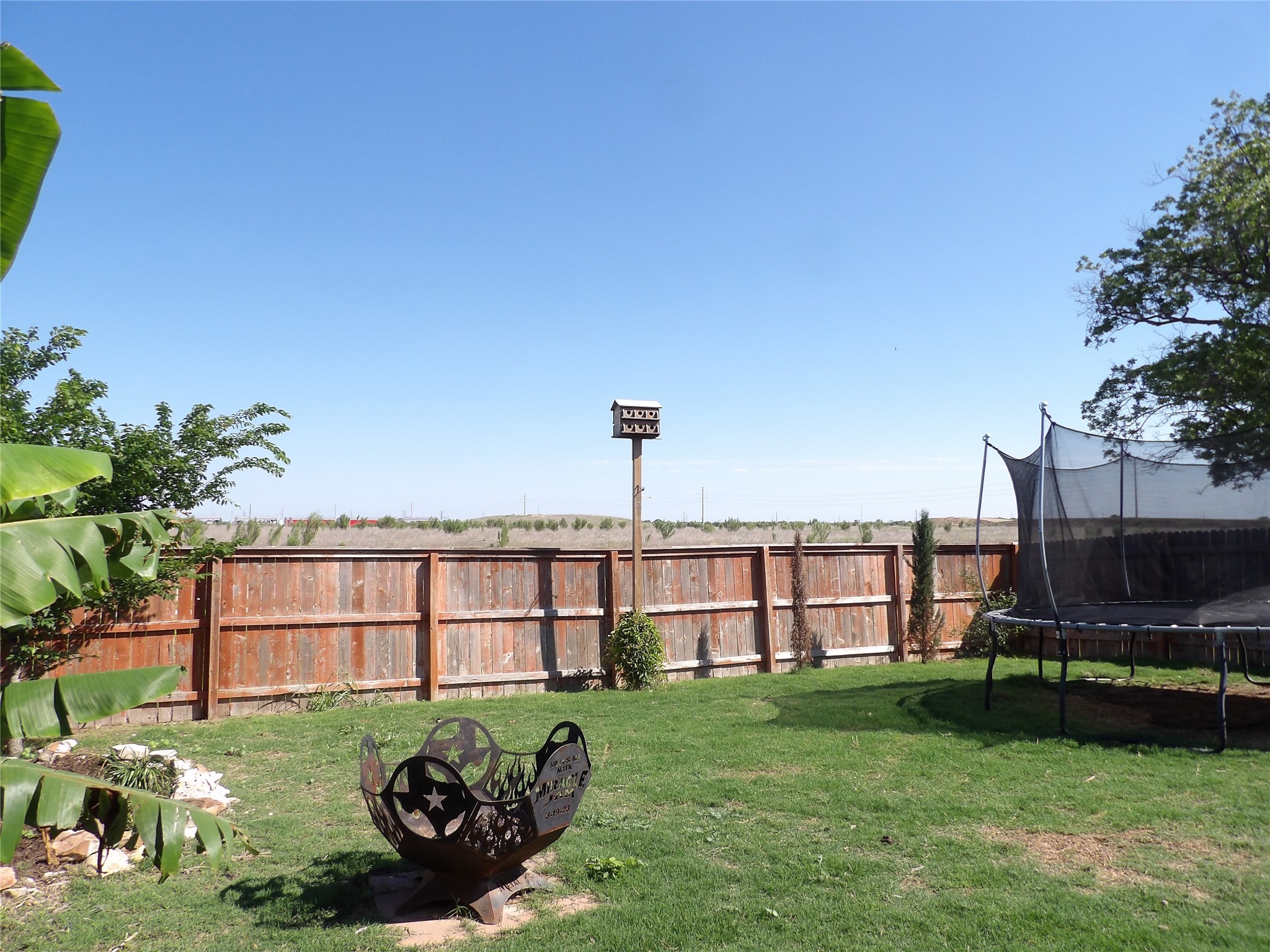 930 Pumpkin Ridge New Braunfels, TX 78130 - Photo 4 of 32 Expansive backyard featuring a manicured lawn, wood privacy fencing, and mature trees