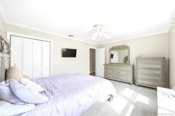 a bedroom with a bed a dresser and a flat screen tv
