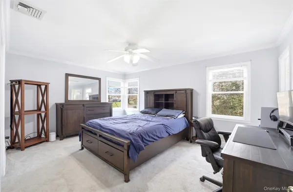 a spacious bedroom with a bed and wooden floor