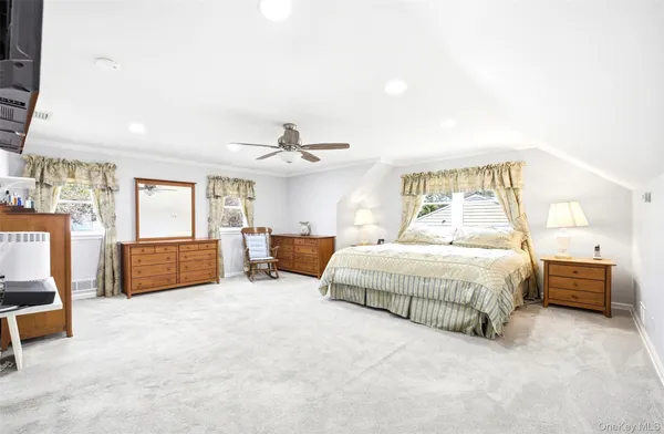 a spacious bedroom with a bed a couch and a chandelier