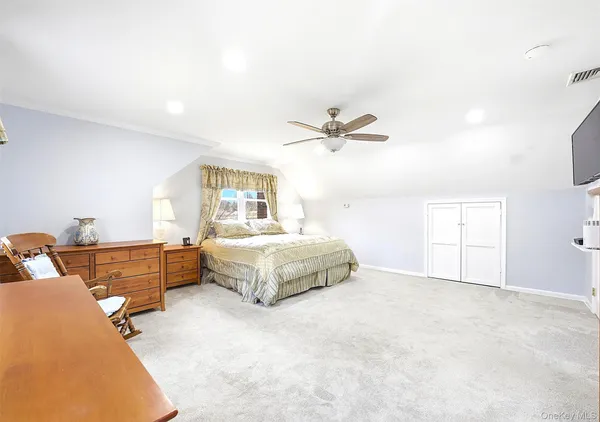 a spacious bedroom with a bed and a chandelier