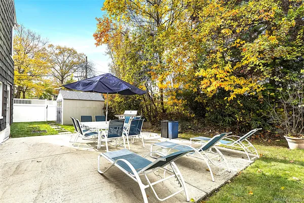 a view of a patio with a table and chairs under an umbrella