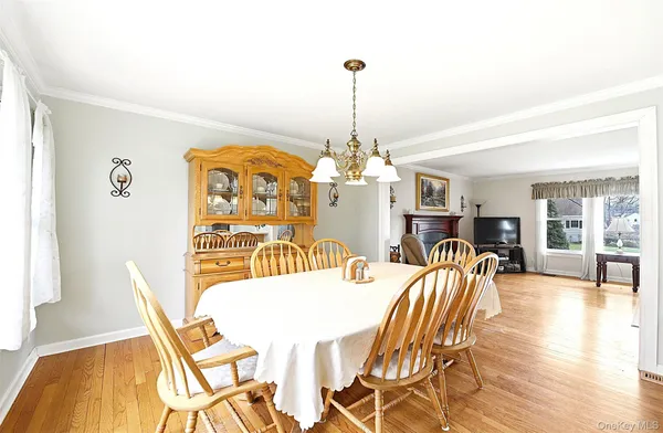 a dining room with furniture a chandelier and wooden floor