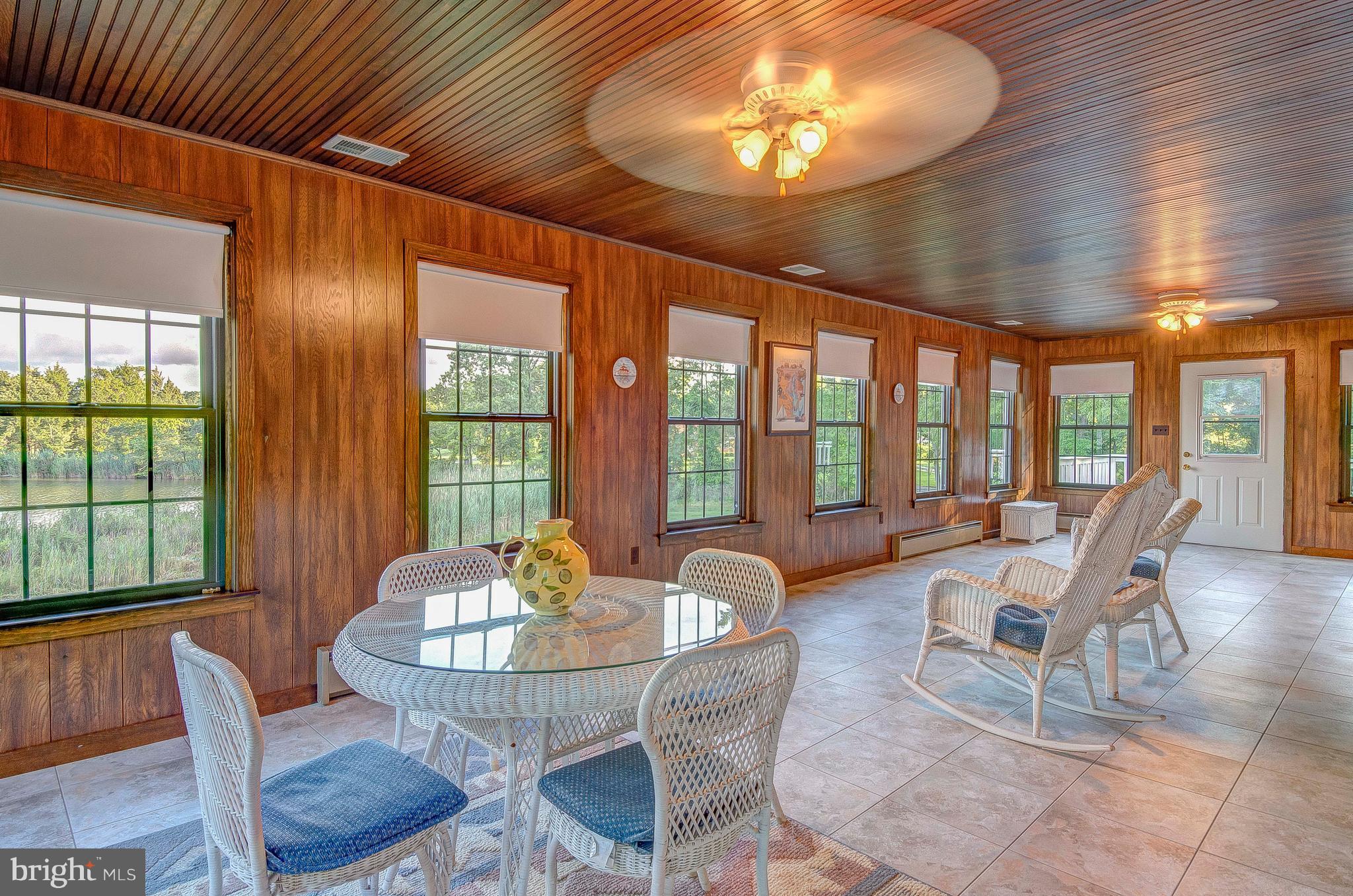 5966 Tyler Road Deale, MD 20751 - Photo 19 of 30 a view of a dining room with furniture large windows and wooden floor