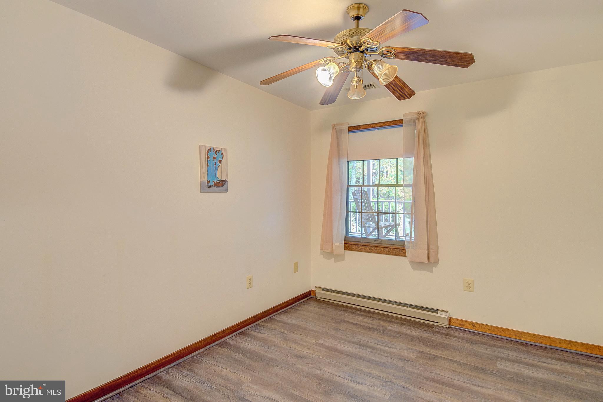 5966 Tyler Road Deale, MD 20751 - Photo 26 of 30 an empty room with wooden floor chandelier fan and windows