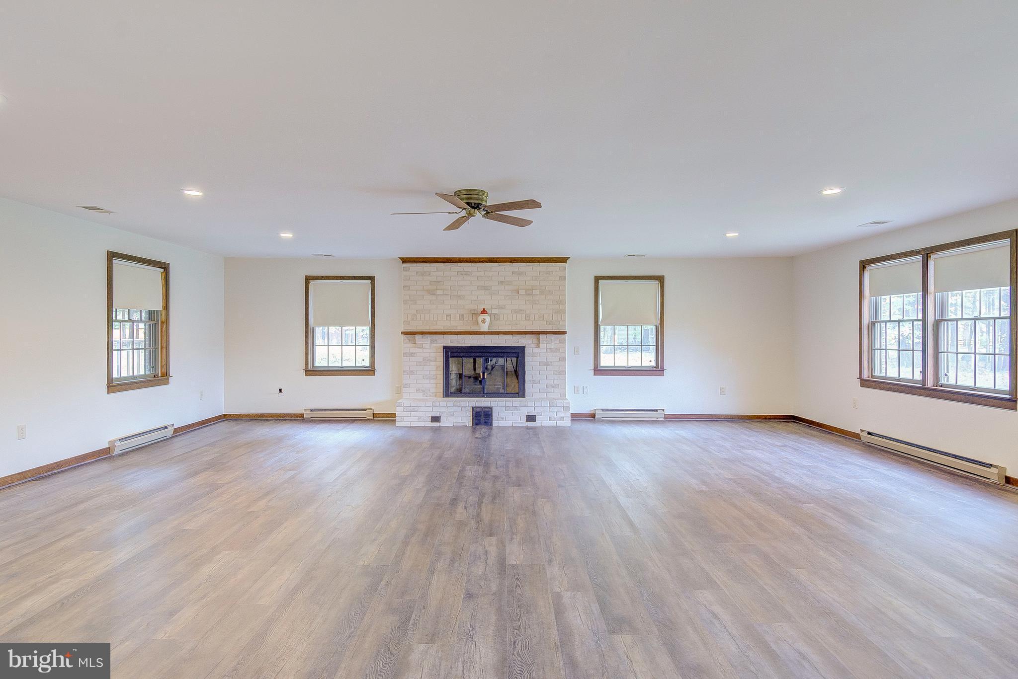 5966 Tyler Road Deale, MD 20751 - Photo 28 of 30 an empty room with wooden floor fireplace and windows