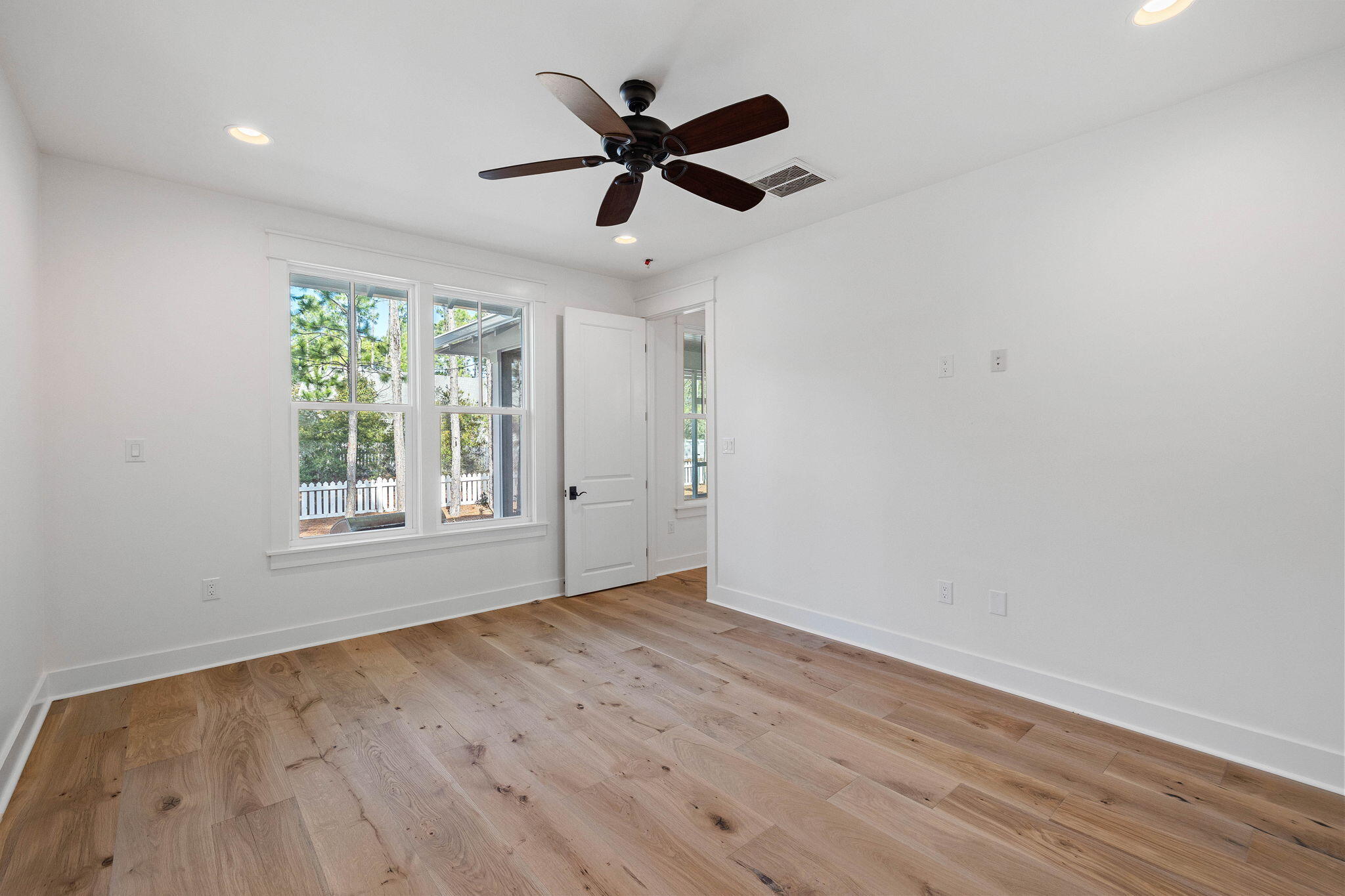 821 Breakers Street Inlet Beach, FL 32461 - Photo 53 of 69 an empty room with wooden floor ceiling fan and windows