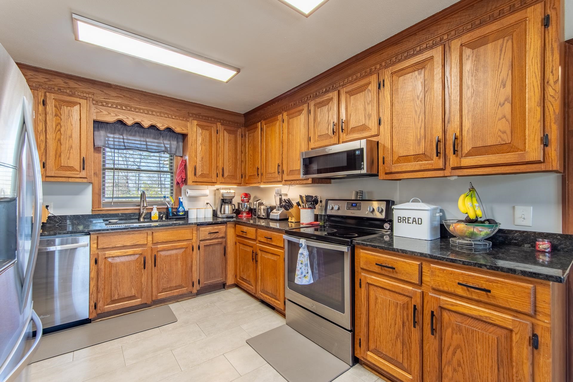 255 Easley Loop Savannah, TN 38372 - Photo 12 of 40 a kitchen with stainless steel appliances granite countertop a stove sink microwave and window