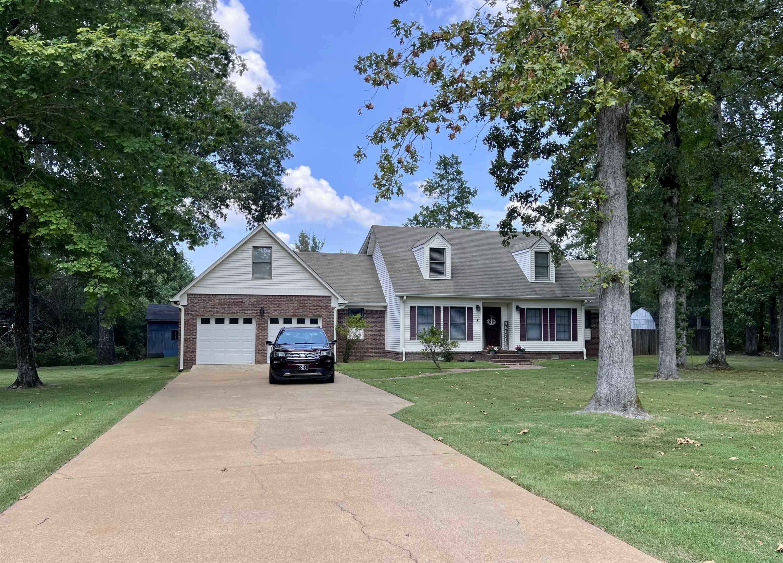 255 Easley Loop Savannah, TN 38372 - Photo 2 of 40 a front view of a house with a garden and trees