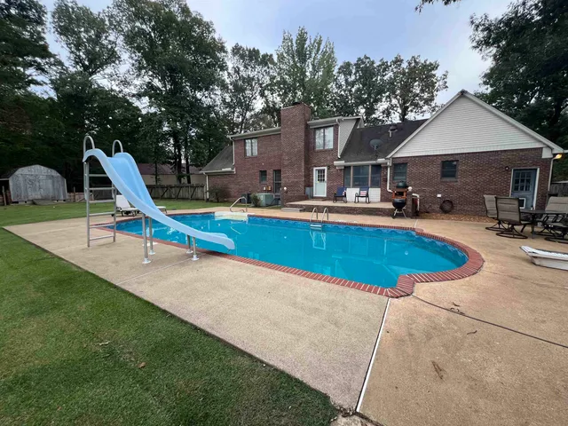 a view of a house with a yard and sitting area