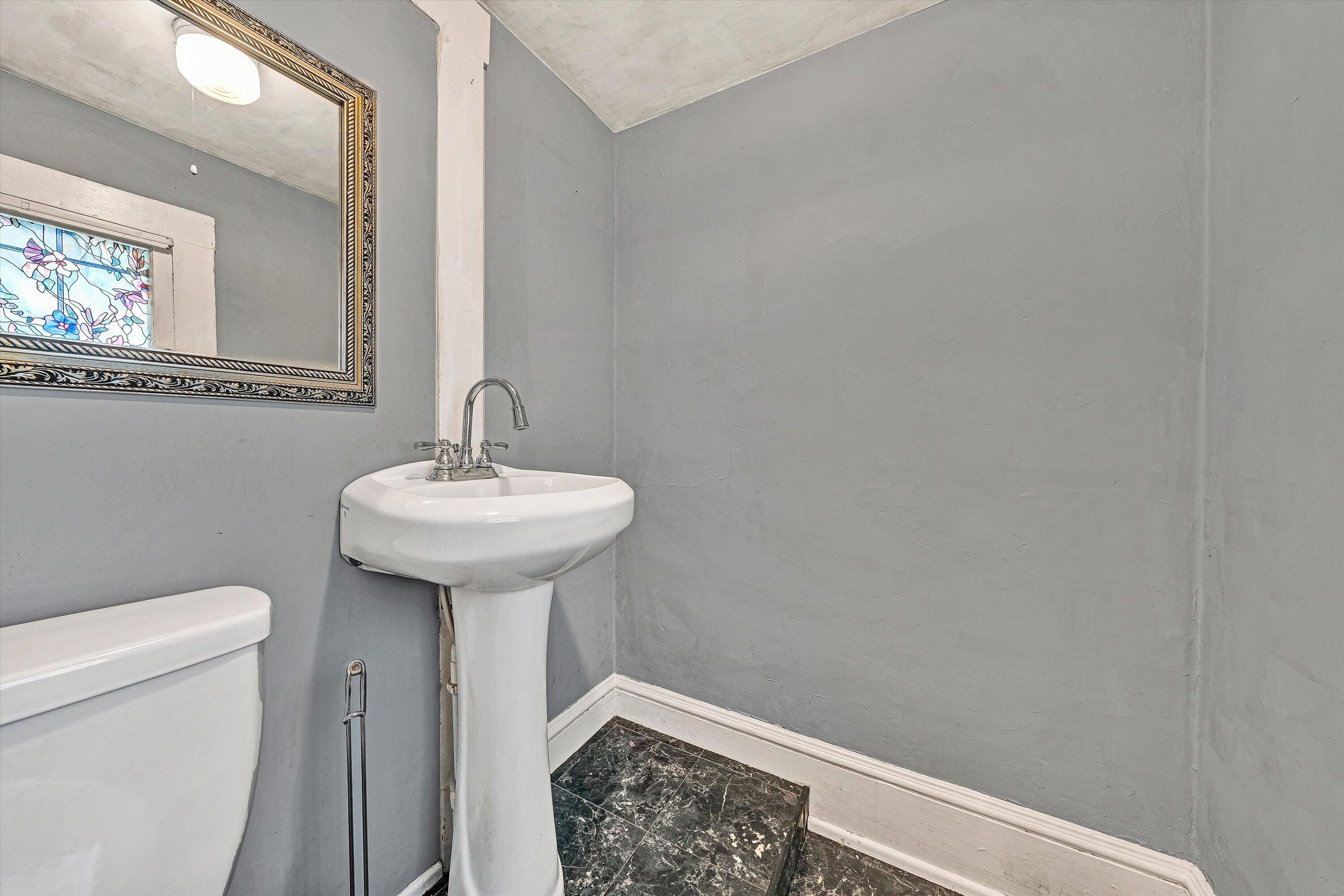1609 6th Street Southwest Roanoke, VA 24016 - Photo 18 of 43 a bathroom with a sink a toilet and a mirror