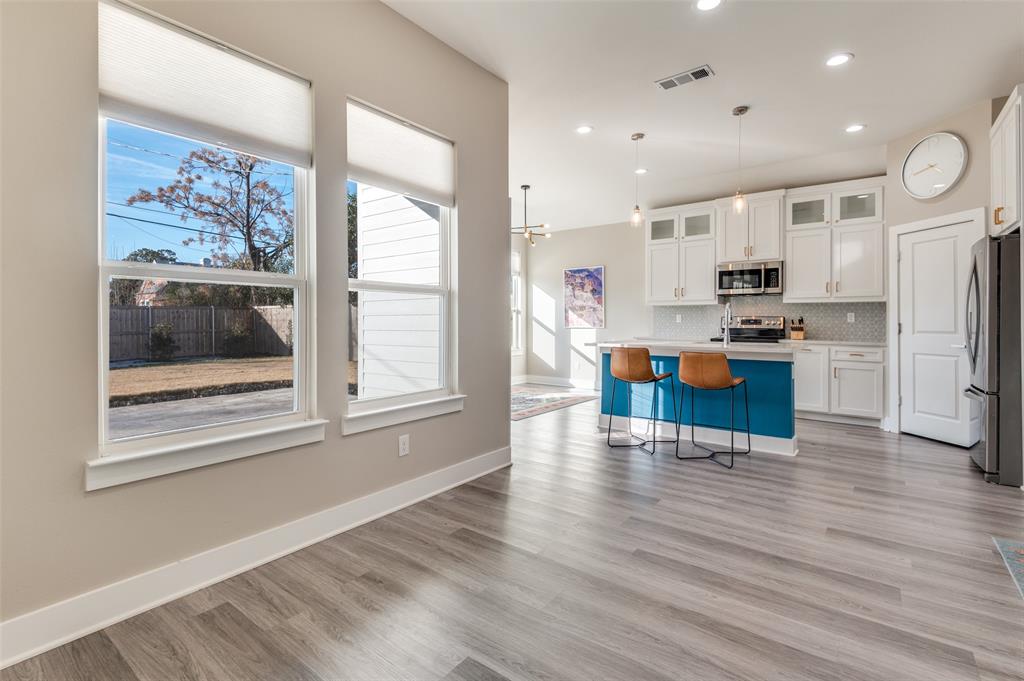 1210 Morrell Avenue Dallas, TX 75203 - Photo 9 of 28 a view of a kitchen with kitchen island stainless steel appliances wooden floor and a refrigerator