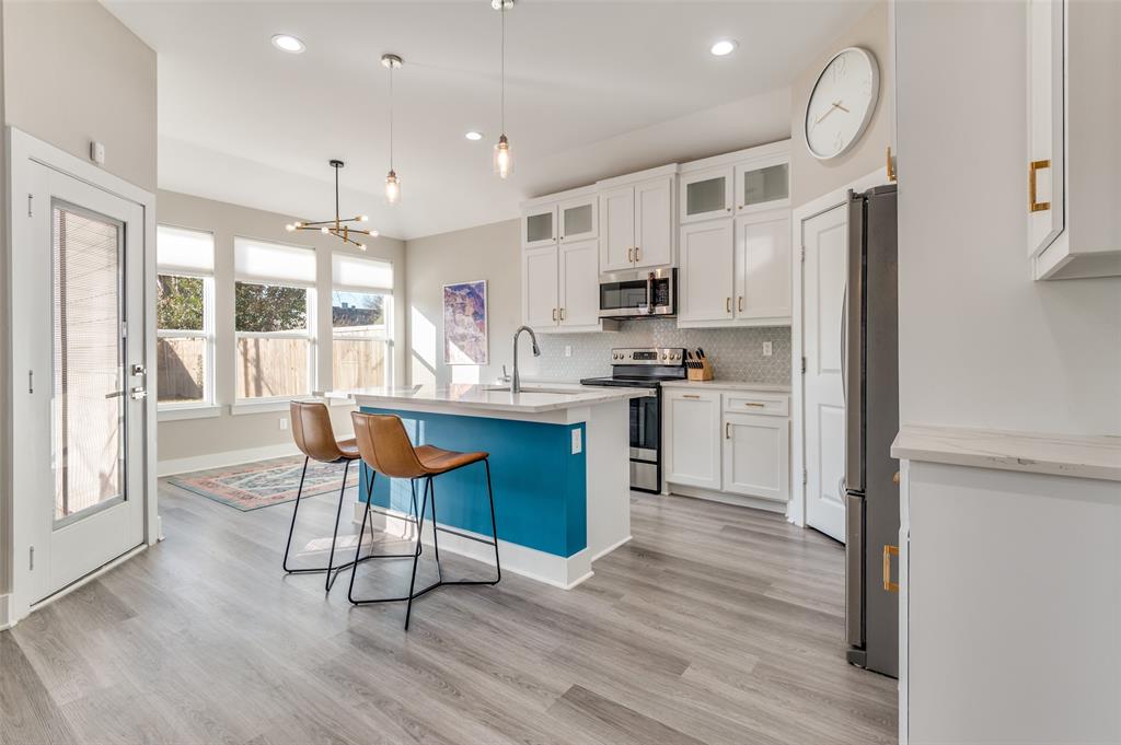 1210 Morrell Avenue Dallas, TX 75203 - Photo 10 of 28 a kitchen with kitchen island granite countertop wooden floors and stainless steel appliances