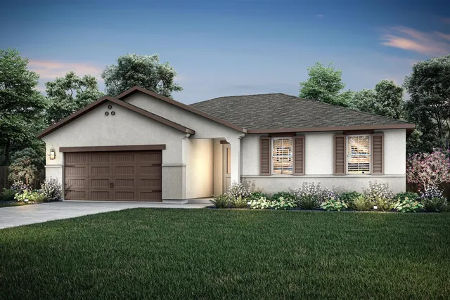 a front view of a house with a garden and plants