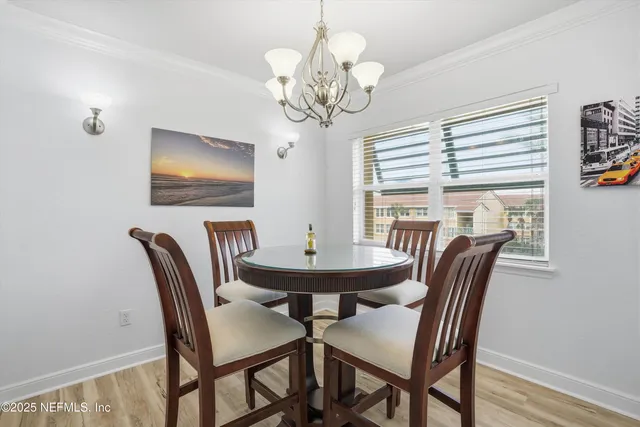 a view of a dining room with furniture a chandelier and wooden floor
