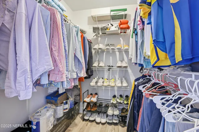 a view of walk in closet with clothes and shoes