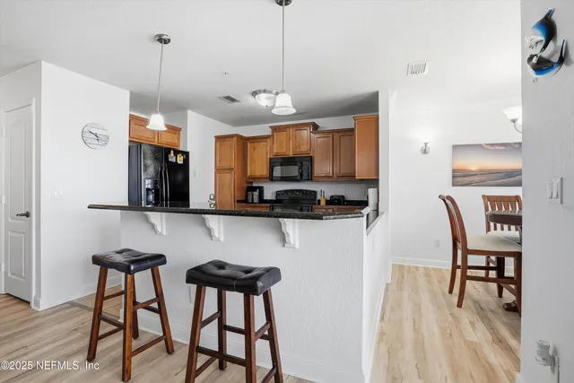 a view of a kitchen with kitchen island dining table and stainless steel appliances