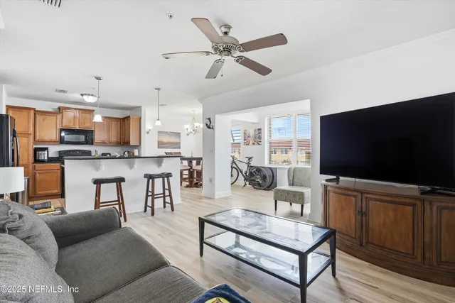 a living room with furniture kitchen view and a flat screen tv