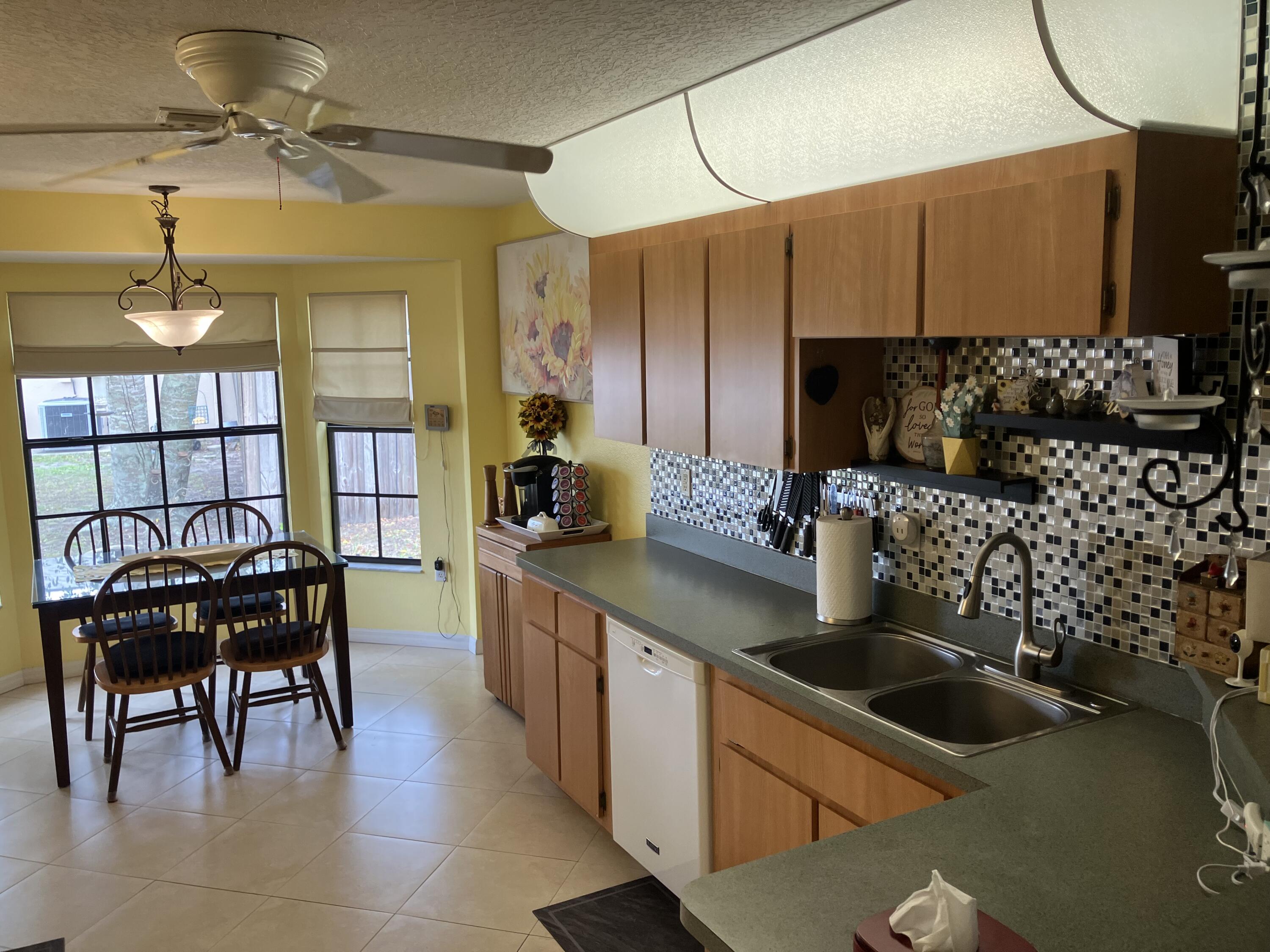 14050 Brighton Street Spring Hill, FL 34609 - Photo 6 of 20 a kitchen with stainless steel appliances a stove a sink a microwave and dining table