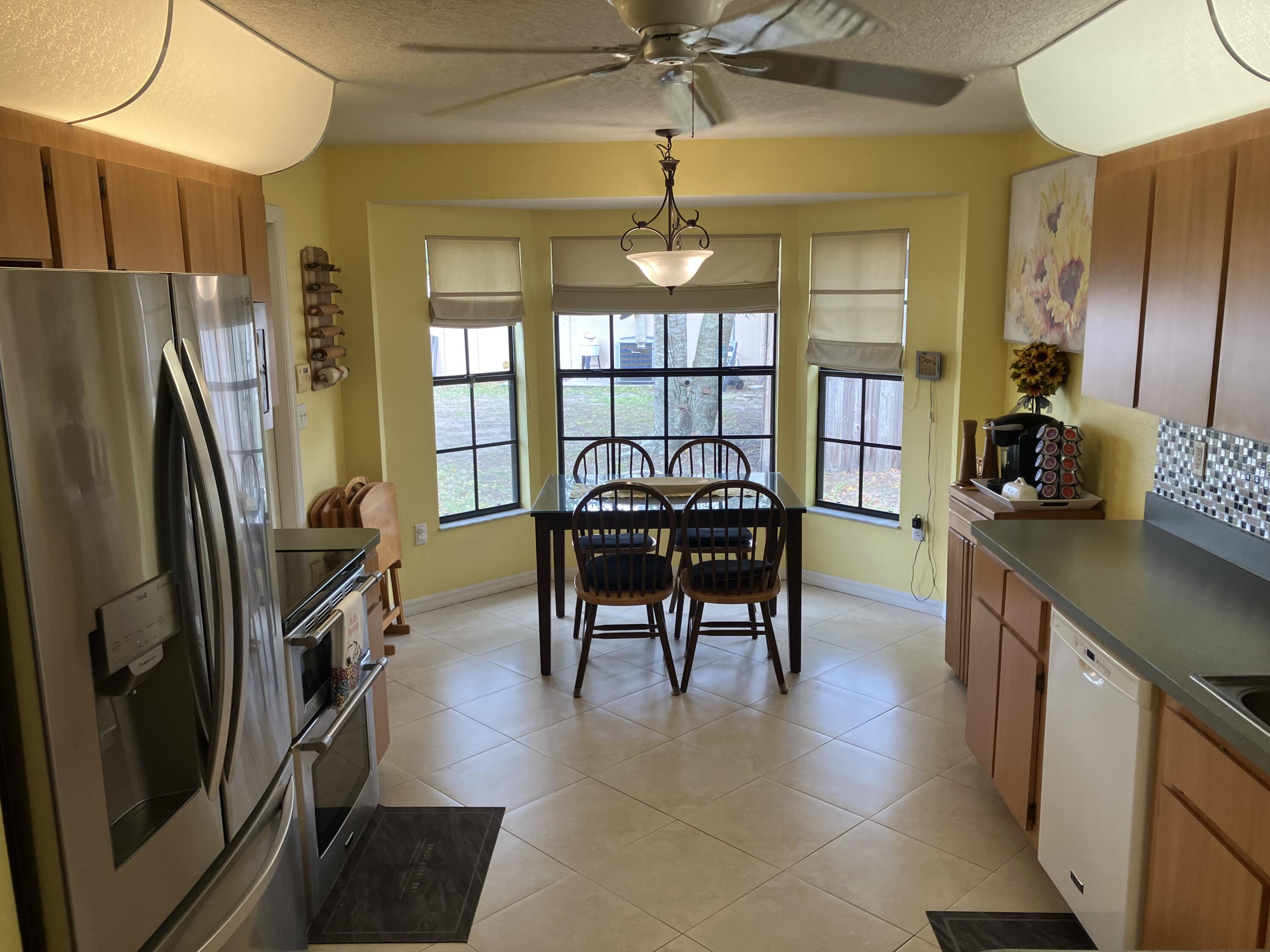 14050 Brighton Street Spring Hill, FL 34609 - Photo 8 of 20 a dining room with furniture a floor to ceiling window and a ceiling fan