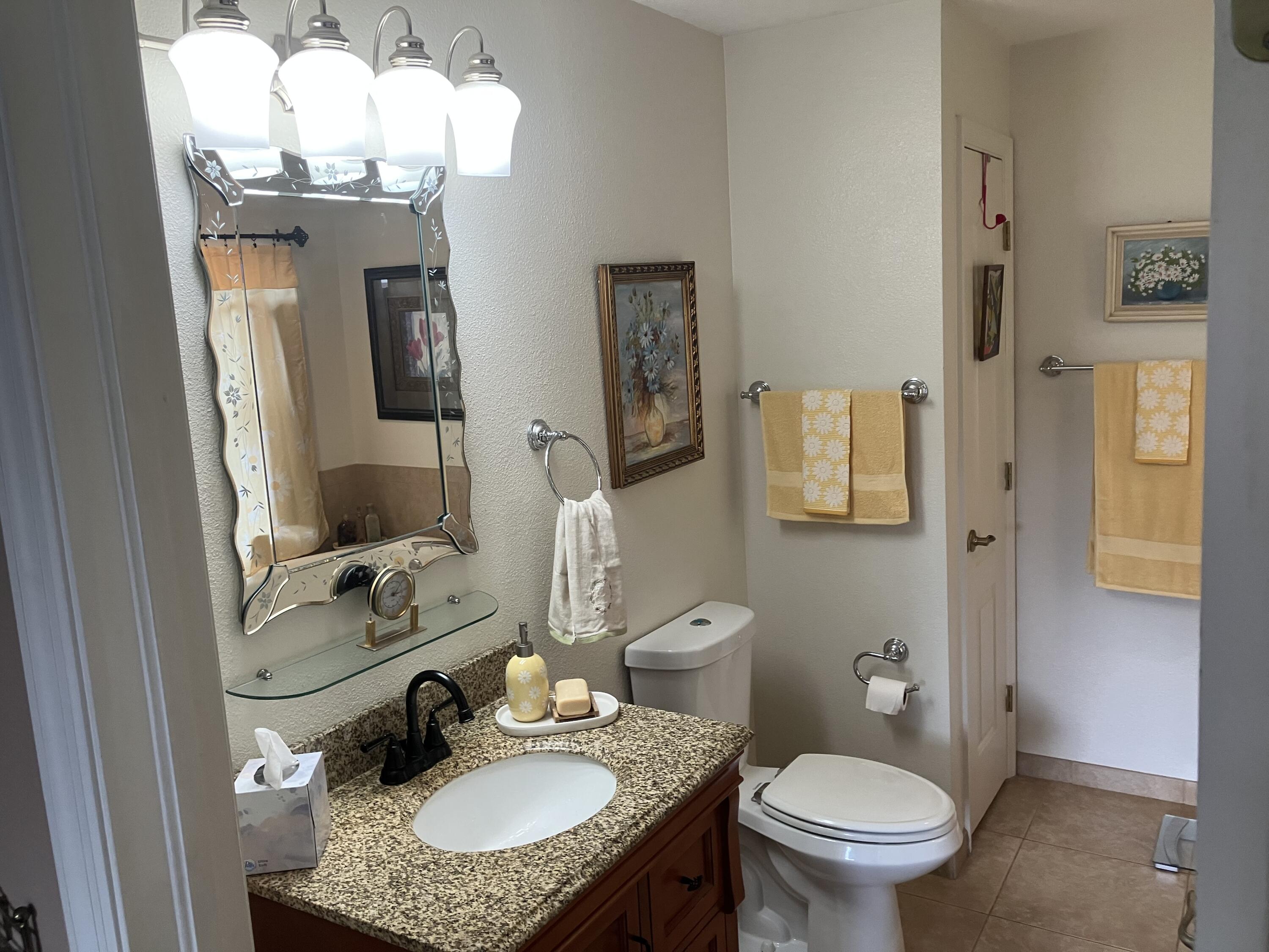 14050 Brighton Street Spring Hill, FL 34609 - Photo 10 of 20 a bathroom with a granite countertop toilet sink and mirror