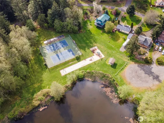 an aerial view of a house with a yard and lake view