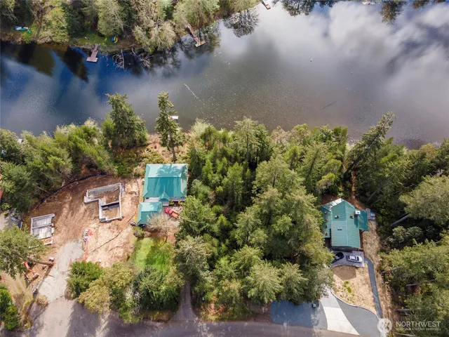 an aerial view of a house with a yard and lake view