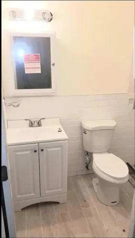 a bathroom with a toilet sink and mirror