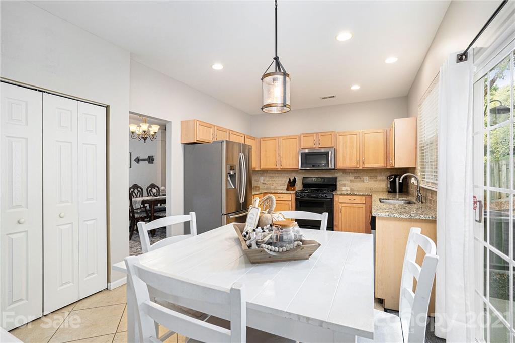 9379 Hillston Ridge Road Huntersville, NC 28078 - Photo 12 of 38 a kitchen with stainless steel appliances granite countertop a refrigerator a stove top oven a sink dishwasher and white cabinets with wooden floor