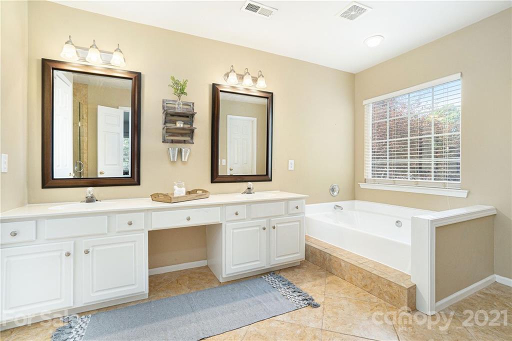 9379 Hillston Ridge Road Huntersville, NC 28078 - Photo 26 of 38 a spacious bathroom with a granite countertop tub sink and mirror