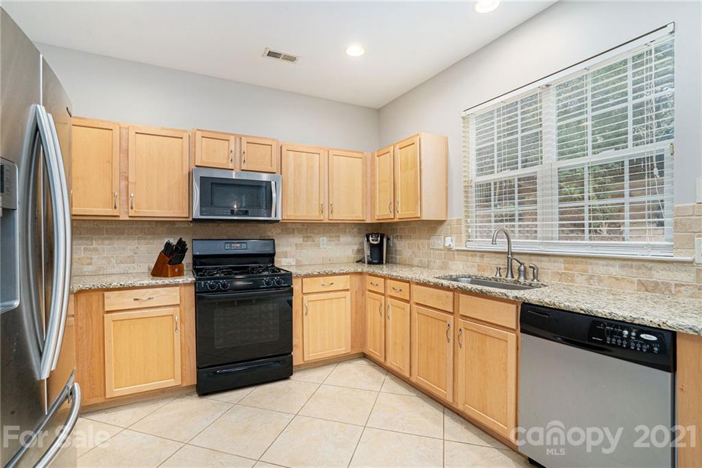 9379 Hillston Ridge Road Huntersville, NC 28078 - Photo 7 of 38 a kitchen with stainless steel appliances granite countertop a stove sink and microwave