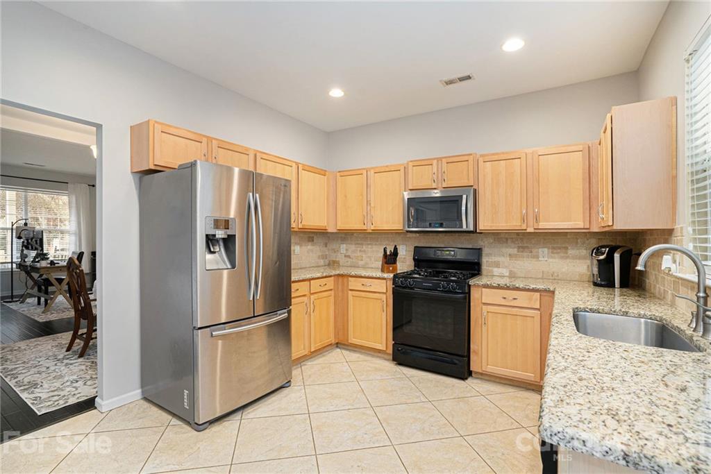 9379 Hillston Ridge Road Huntersville, NC 28078 - Photo 8 of 38 a kitchen with granite countertop a refrigerator and a stove top oven