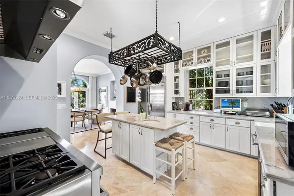 a kitchen with granite countertop a sink stove and white cabinets