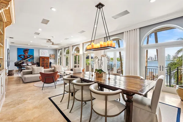 a dining room with furniture a chandelier and wooden floor