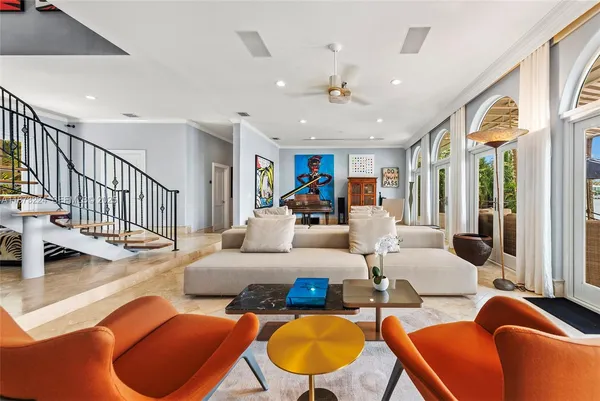 a living room with furniture kitchen view and a large window