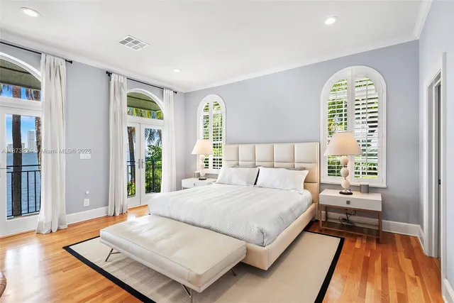 a spacious bedroom with a bed and wooden floor