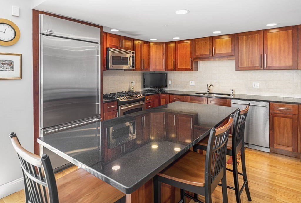44 Prince Street, Unit 412 Boston, MA 02113 - Photo 6 of 19 a kitchen with stainless steel appliances granite countertop a stove a sink a microwave and a refrigerator